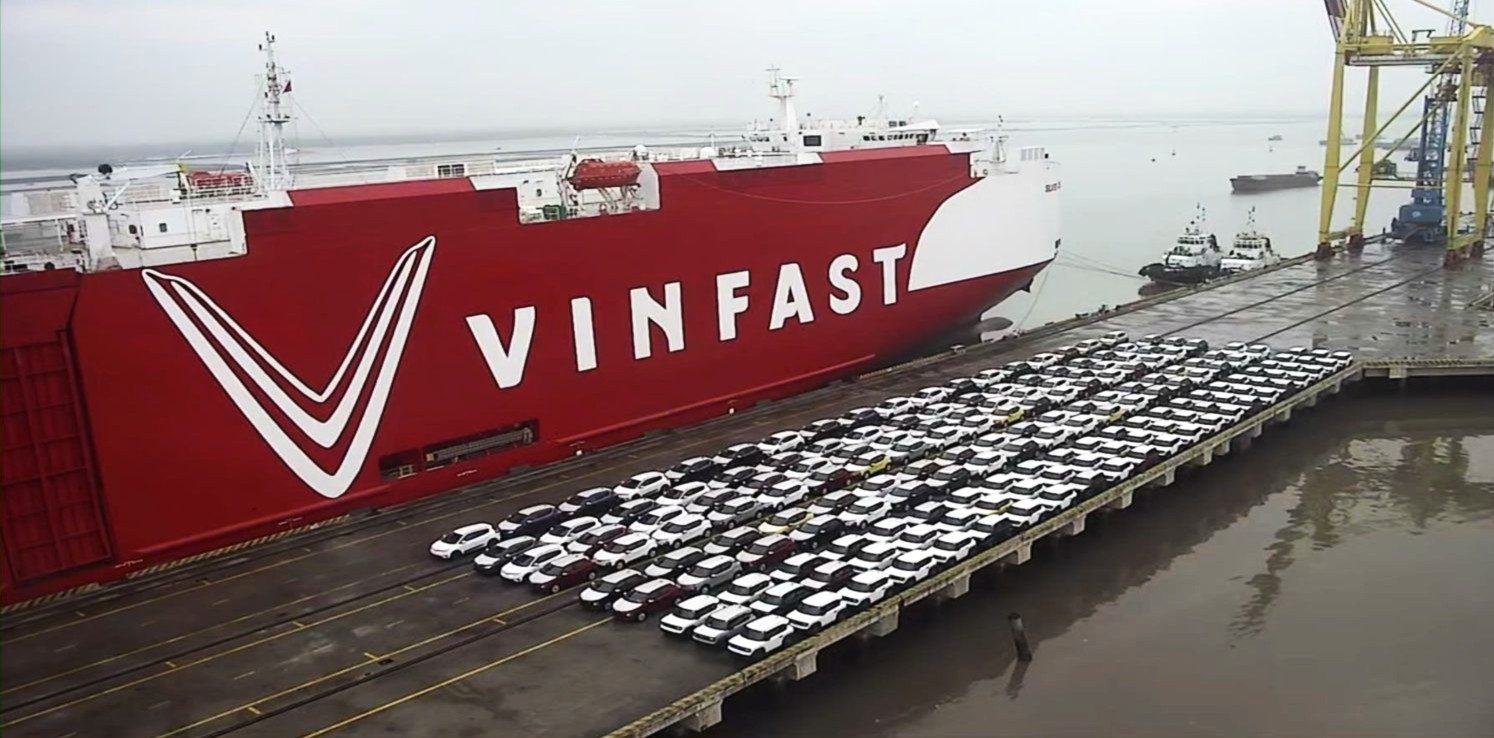 Rows of vehicles ready for loading beside a PCTC vessel